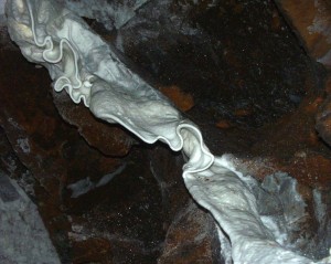 A curtain-like formation - the result of calcium carbonate-rich water running along the ceiling of the Sterkfontein Quarry Cave. It would probably have taken millennia to form a curtain of this size!